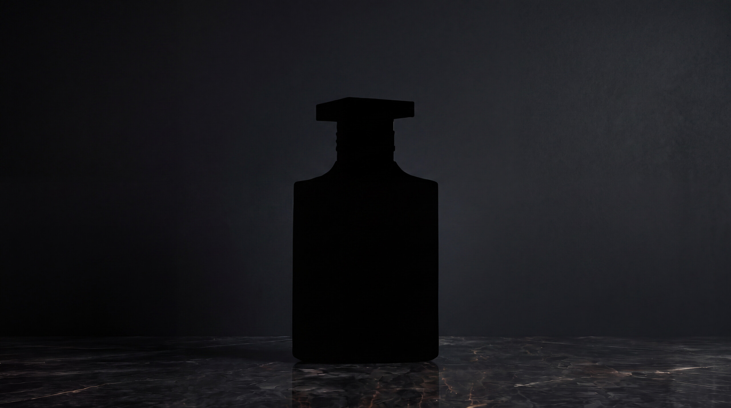 The Extension — a matte black flacon in near-darkness, on polished marble.